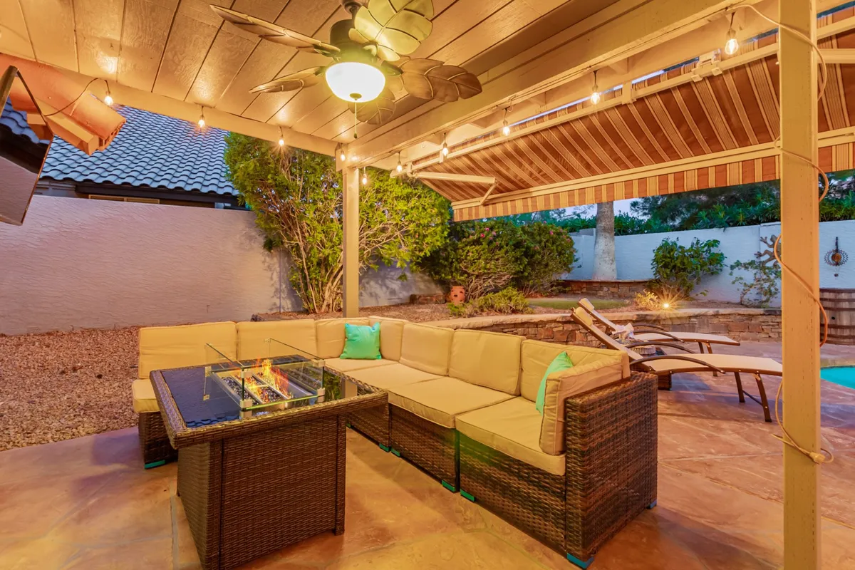 An inviting outdoor fire pit table surrounded by comfortable seating and softly glowing decorative lighting, creating a cozy setting for evening gatherings. The space is designed for relaxation and socializing under the stars, ideal for making s’mores or sharing stories with family and friends.